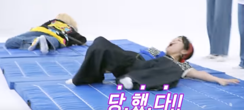 JiU flat on her back while Handong belly crawls towards the candy tray